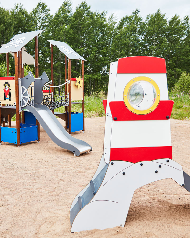 Submarine shaped slide, located at a playground with sea and pirate theme.